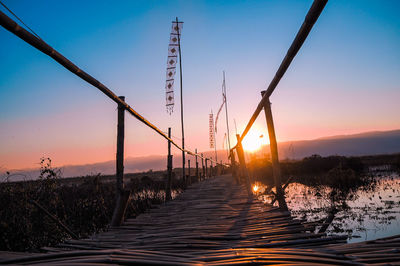 Silhouette bridge against sky during sunset