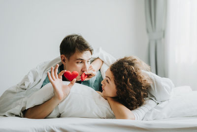 Portrait of friends lying on bed