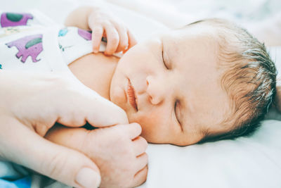 Close-up of baby sleeping on bed