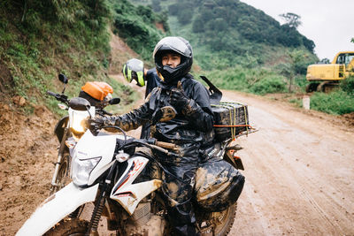 Portrait of man riding motorcycle on road