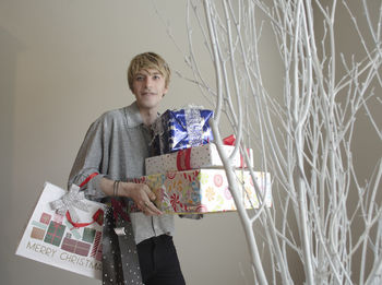Portrait of young woman standing by plants