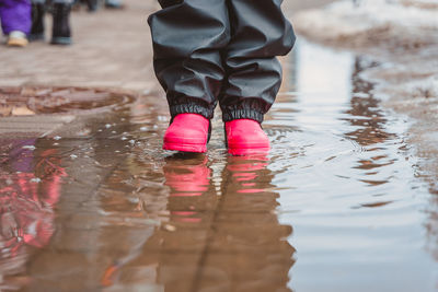 Low section of woman standing in water