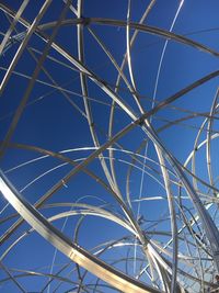 Low angle view of metallic structure against blue sky