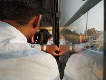 Rear view of man seen through glass window