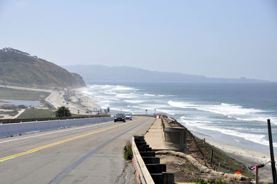 Road by sea against clear sky