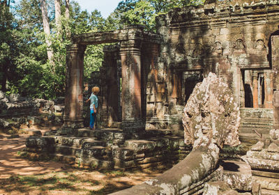 Mid adult woman standing outside ankor wat temple