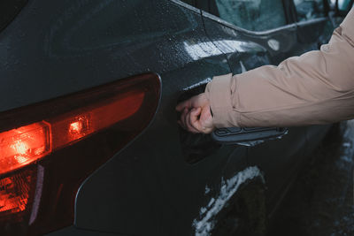 Cropped hand of man washing car