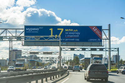 Road sign against sky in city