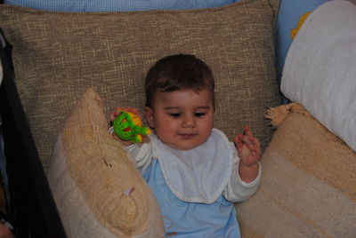 High angle view of cute baby boy relaxing on bed at home