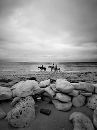 People standing on beach against sky