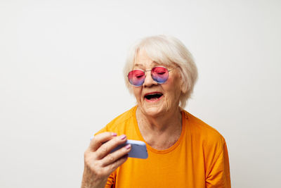 Senior woman using mobile phone against white background