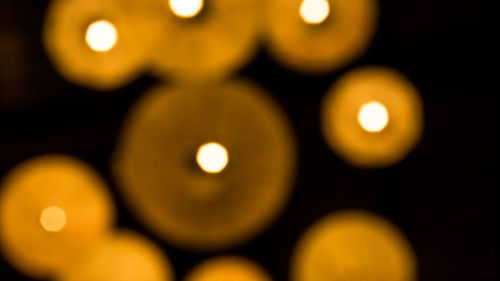 Close-up of illuminated lighting equipment against black background