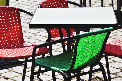 High angle view of empty chairs and table at sidewalk cafe