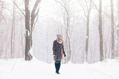 Full length of woman standing on snow covered land