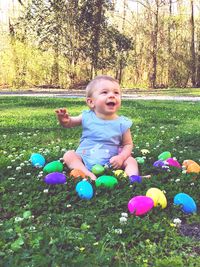 Portrait of happy boy playing with trees in park