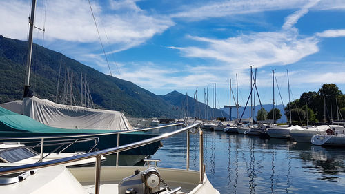 Sailboats moored at harbor against sky