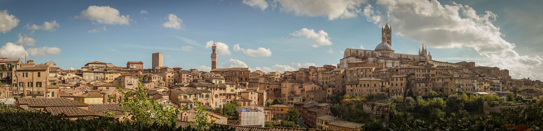 Panoramic view of buildings in city against sky