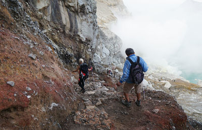 A man and woman going down to the crater of mount ijen in banyuwangi, indonesia.