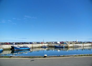 Moored boats by retaining wall on river