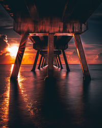 Pier on sea against sky during sunset