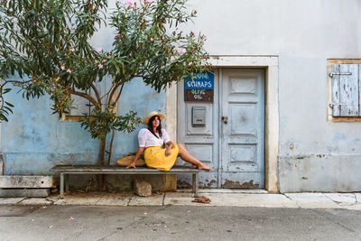 Man sitting on seat against building