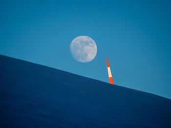 Low angle view of moon against blue sky