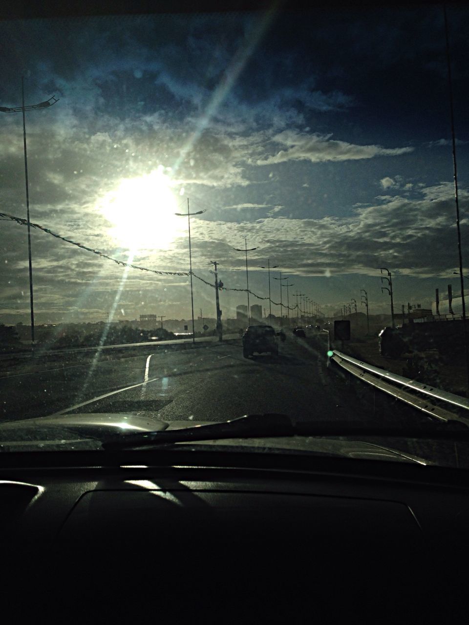 transportation, mode of transport, car, road, land vehicle, sky, vehicle interior, sun, windshield, sunbeam, on the move, lens flare, sunlight, glass - material, road marking, travel, transparent, cloud - sky, connection, street