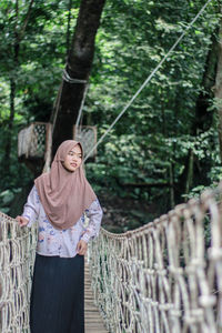 Woman standing against trees in forest