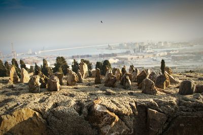 Stones on hill with city in background