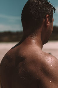 Rear view of shirtless man in water