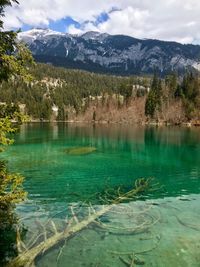Scenic view of lake by mountains against sky