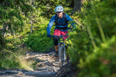 Man riding a mountain bike on footpath in the austrian alps, saalbach, austria