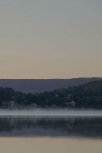 Scenic view of lake against clear sky at sunset