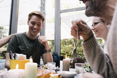 Smiling man having food with family at restaurant