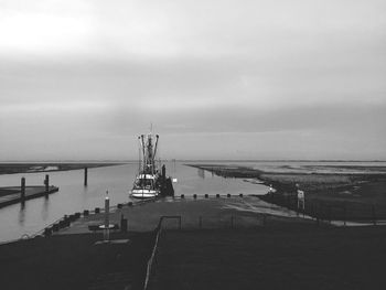 Boat moored at harbor against sky