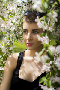 Close-up of young woman with flower tree