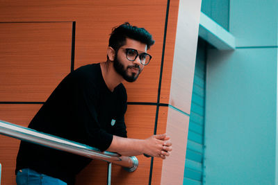 Young man standing against wall