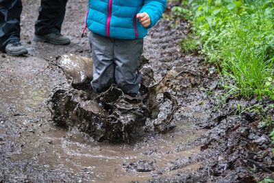 Low section of person standing by stream