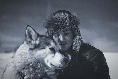 Young man with siberian husky on field during winter