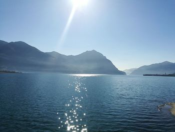 Scenic view of sea and mountains against clear blue sky