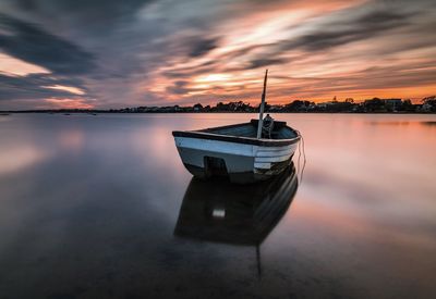 Scenic view of sea against cloudy sky at sunset