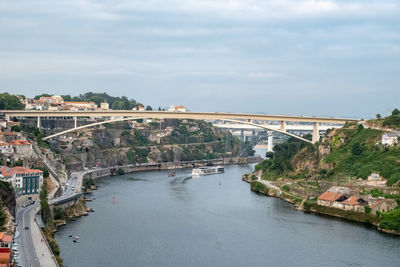 Arch bridge over river amidst buildings in town