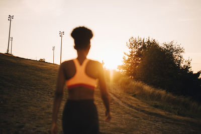 Rear view female athlete looking at sunset