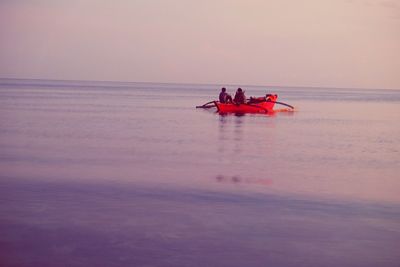 Men on boat in sea against sky