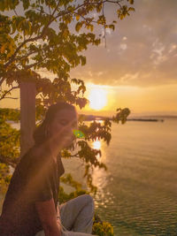 Man on beach against sky during sunset