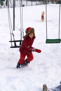 Boy playing on snow covered land