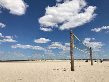 Wooden posts on beach against sky