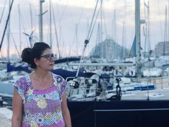 Mature woman at harbor against sky in la grande-motte during sunset