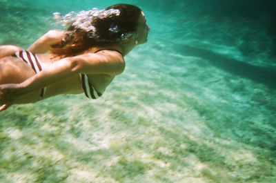 Low section of woman swimming in sea