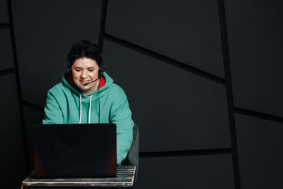 Portrait of smiling young man using laptop